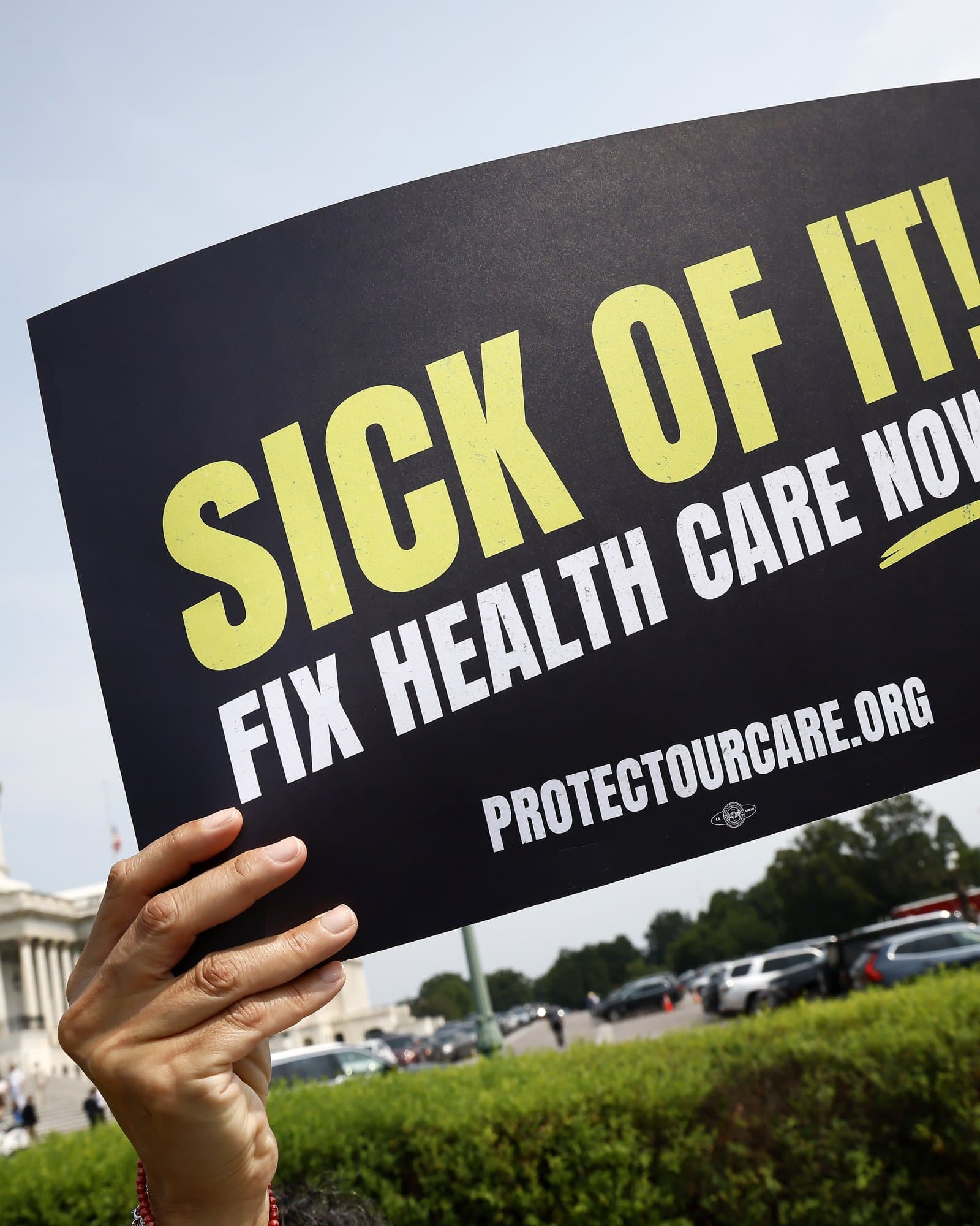 A supporter holds a Sick Of It! Fix Health Care Now sign at the U.S. Capitol.